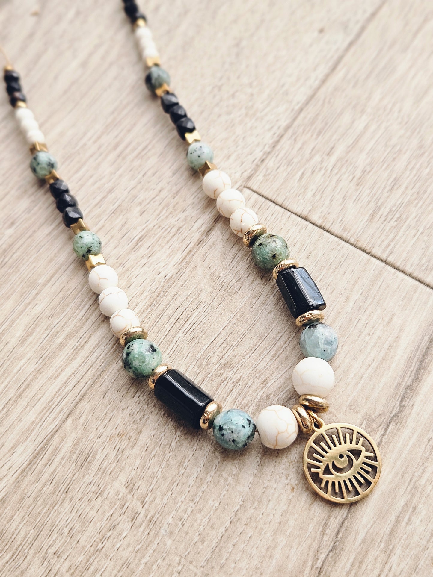 Collar con turquesa africana, turquesa blanca y turmalina negra con un colgante que representa el Ojo de Ra