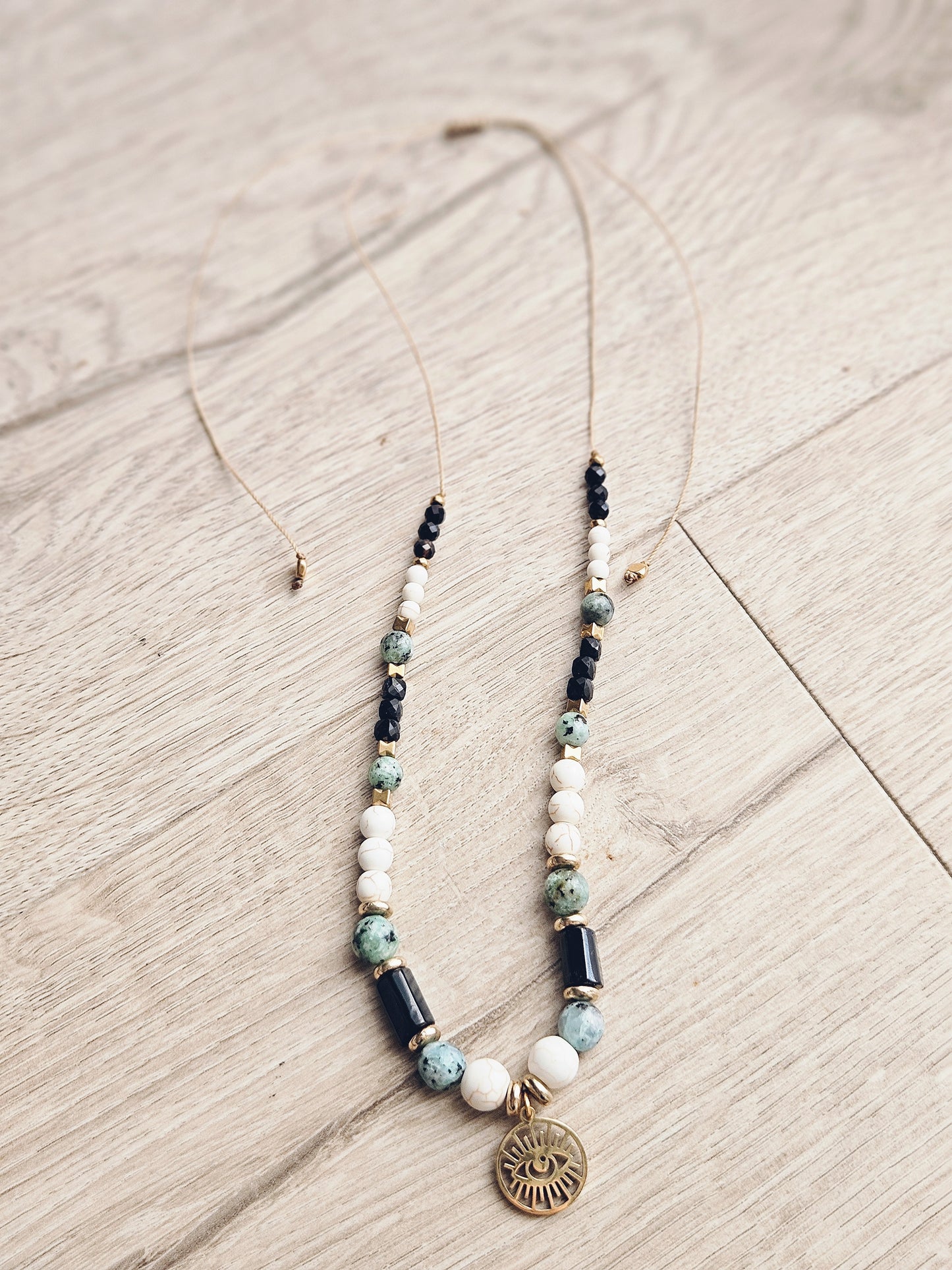 Collar con turquesa africana, turquesa blanca y turmalina negra con un colgante que representa el Ojo de Ra