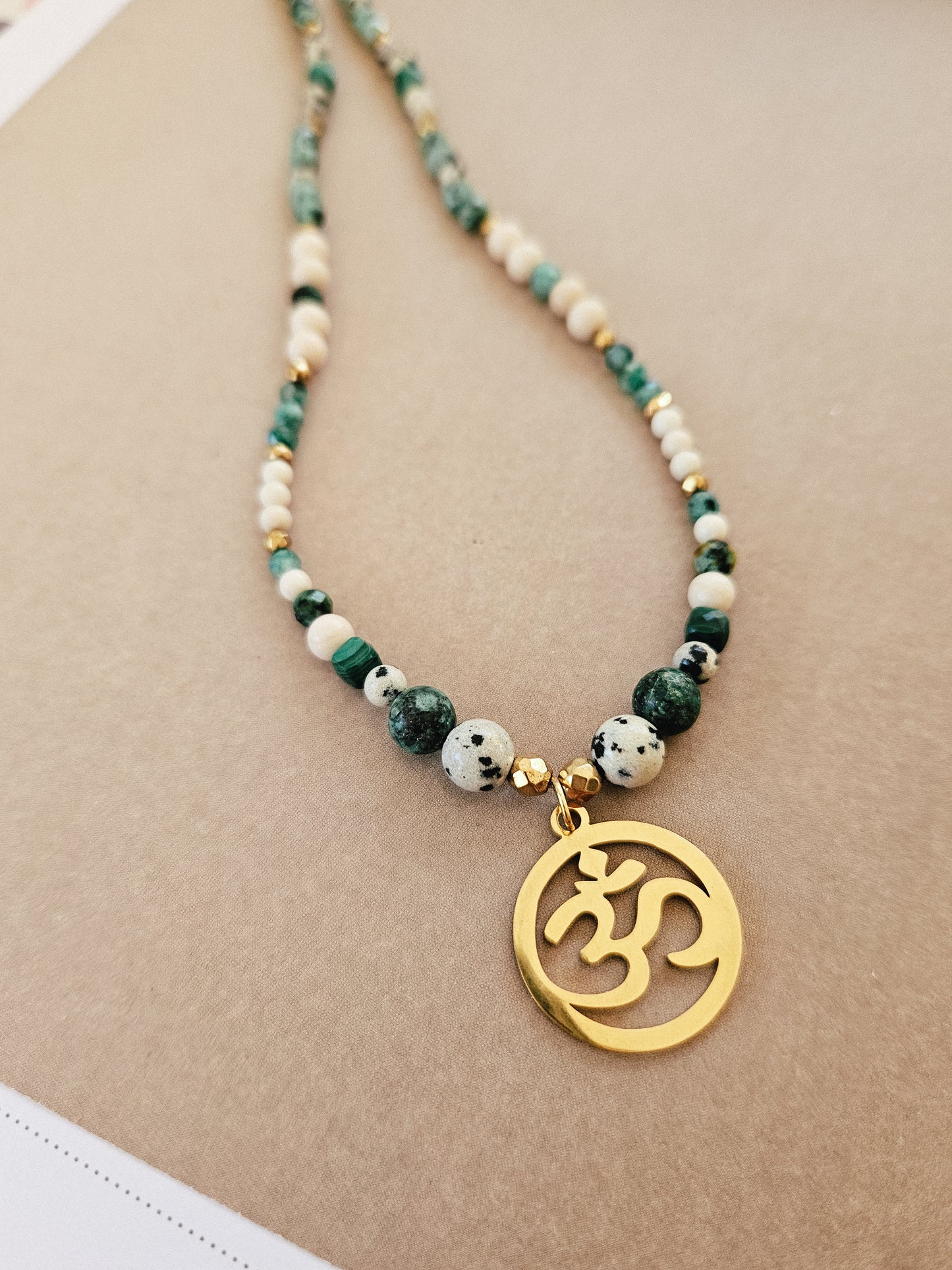 Collar elaborado con Piedras Naturales: Malaquita, Turquesa Africana, Piedra de Río, Jaspe Dálmata y Hematites con colgante del Signo "Om"