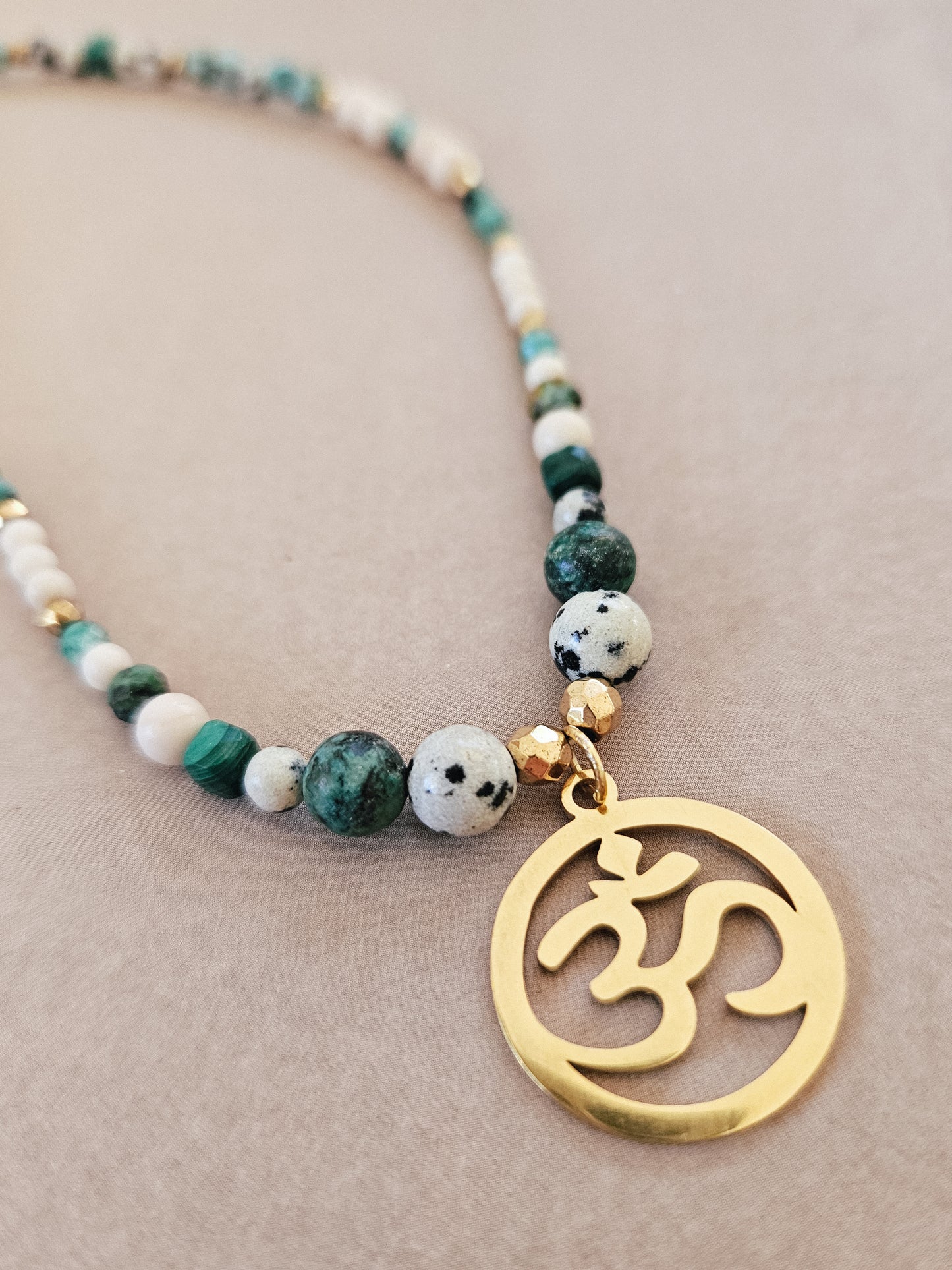Collar elaborado con Piedras Naturales: Malaquita, Turquesa Africana, Piedra de Río, Jaspe Dálmata y Hematites con colgante del Signo "Om"