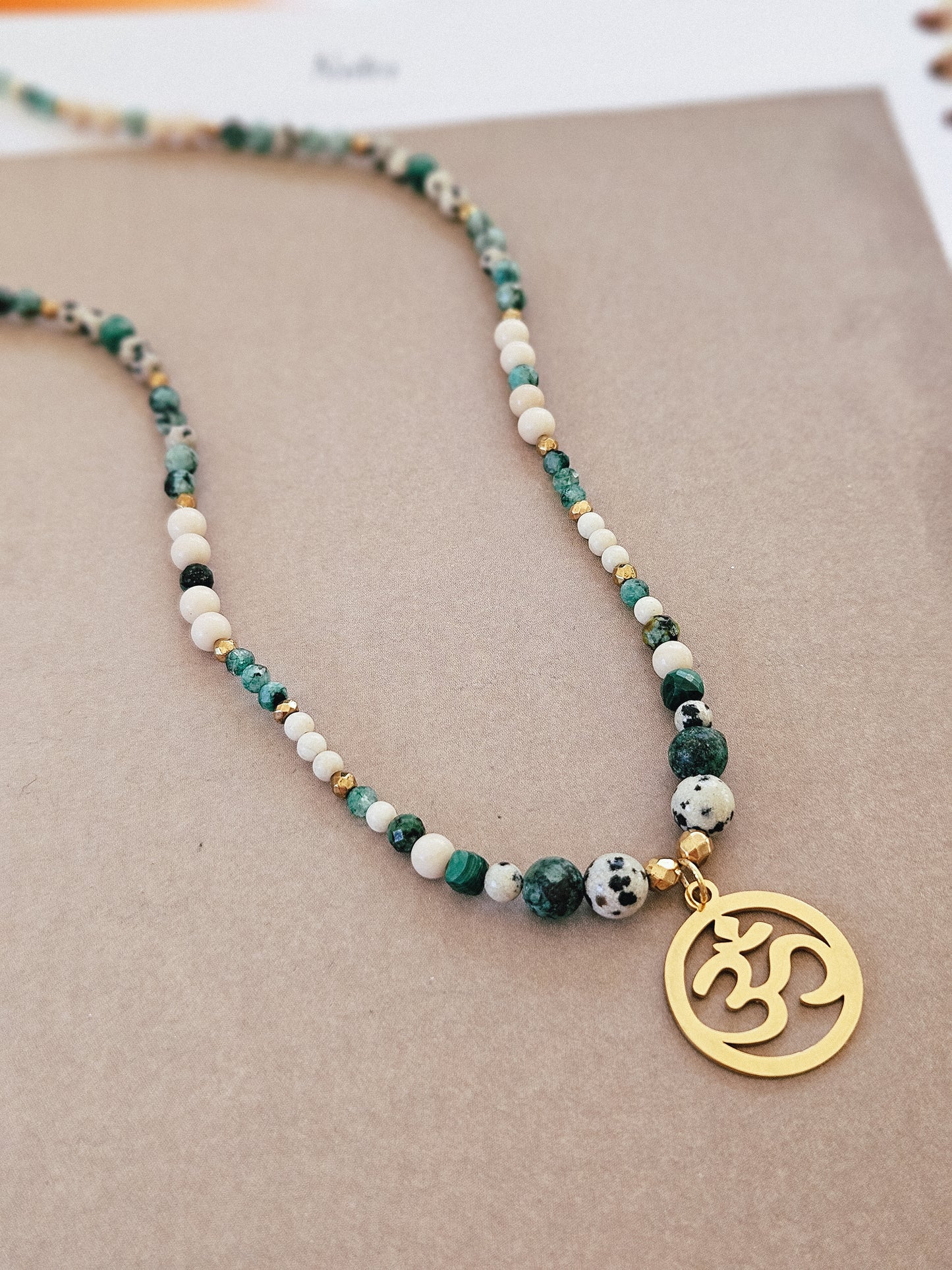 Collar elaborado con Piedras Naturales: Malaquita, Turquesa Africana, Piedra de Río, Jaspe Dálmata y Hematites con colgante del Signo "Om"