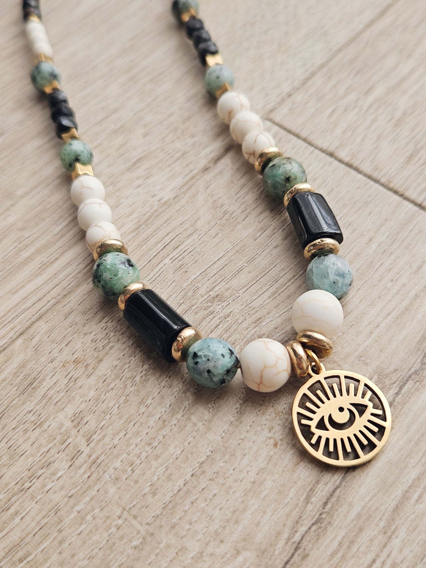 Collar con turquesa africana, turquesa blanca y turmalina negra con un colgante que representa el Ojo de Ra